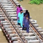 People passing water canal through railway bridge at Tando Yousuf area