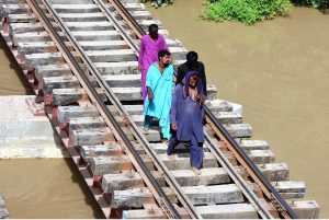 People passing water canal through railway bridge at Tando Yousuf area