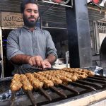 A vendor busy in preparing traditional “Seekh Kabab” in a local hotel in Federal Capital