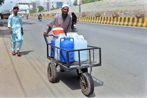 A person pushing his hand cart loaded with clean drinking water supply to Market