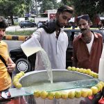 A vendor preparing summer drink (Lemonade) for customers at his roadside setup at Abpara Market