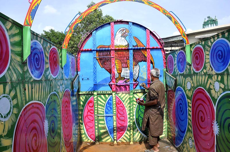 A painter paints the body of a delivery truck at his workplace