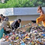Gypsy family searching for valuable things from the heap of garbage