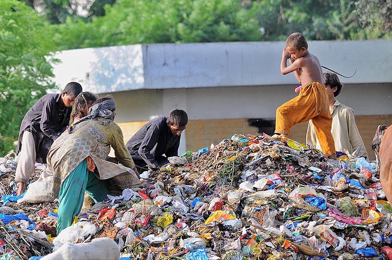 Gypsy family searching for valuable things from the heap of garbage