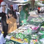 A large number of women and children select national flag and other stuffs displayed along the roadside as the nation start to celebrate the Independence Day with evangelism across the country