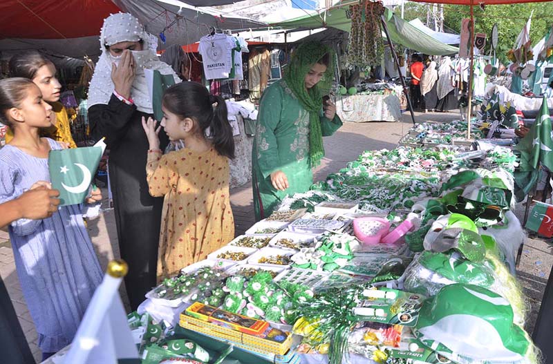 A large number of women and children select national flag and other stuffs displayed along the roadside as the nation start to celebrate the Independence Day with evangelism across the country