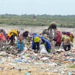 Gypsies searching valuable items at heap of garbage at Latifabad