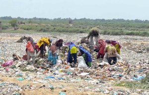 Gypsies searching valuable items at heap of garbage at Latifabad