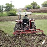 Farmer is busy preparing his farm field with the help of a tractor