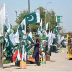Vendor displaying National flags to attract the customers as the nation starts preparations to celebrate Independence Day in befitting manners at Ring road