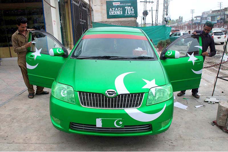 Youngsters are holding flags displayed by a vendor at the roadside, aiming to attract customers as the nation begins preparations to celebrate Independence Day with fitting celebrations