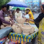 Vendor is selling hand-made baskets while shuttling on the road