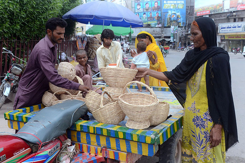 Vendor is selling hand-made baskets while shuttling on the road