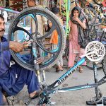 A mechanic busy in repairing a cycle at Liaqat Market