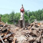 Laborer is cutting firewood into pieces at his workplace near Charsadda Road
