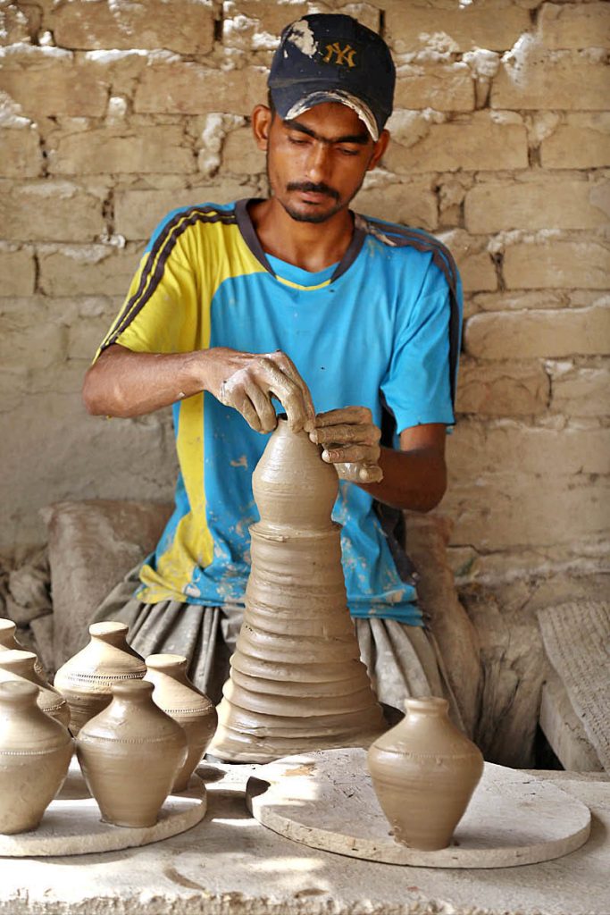 A craftsman busy in preparing clay-made stuff at his work place in Kumhar para at Jamshoro road