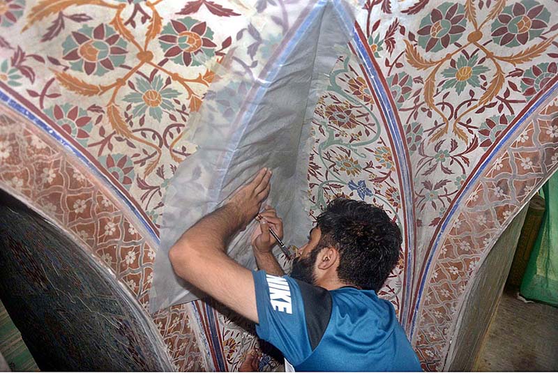 Labourers busy in restoration work on the wall of historical Shahi Qila