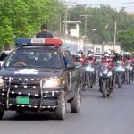 A view of security personnel holding flag march to develop a sense of protection among the masses and maintain law and order situation