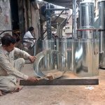 A worker is preparing large iron boxes for the customers at his workplace