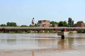 A gypsy crossing Phuleli canal on water supply pipeline at Tandi yosuf