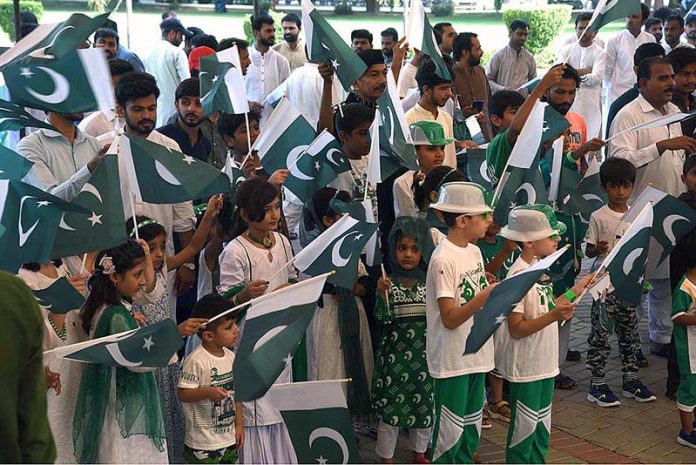 Children are reciting the National anthem and waving the National flag during Flag hoisting ceremony at Punjab Assembly on the occasion of 77th Independence Day celebration