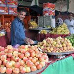 A vendor arranging and displaying Fruits to attract the customers at weekly bazaar, Peshawar Morr