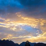 An attractive and eye catching view of sun rays peeping from clouds during rain in city