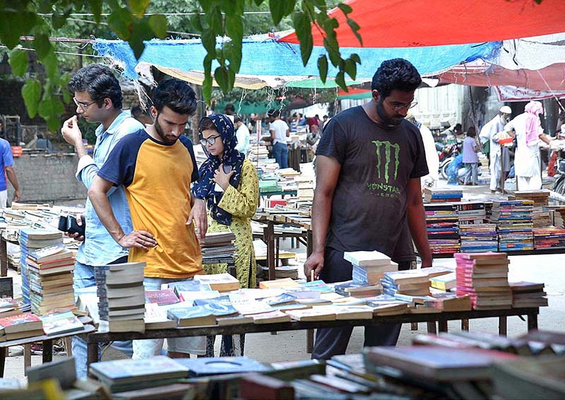 Book lovers selecting old books on a roadside stall in the city