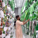 In anticipation of Pakistan's upcoming Independence Day celebrations, a shopkeeper proudly showcases children's suits adorned with Pakistani flags in his shop