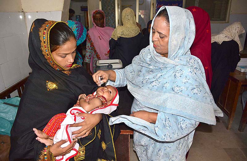 Health worker administering polio vaccine drops to a child during a Polio vaccination campaign at Bhitai Hospital