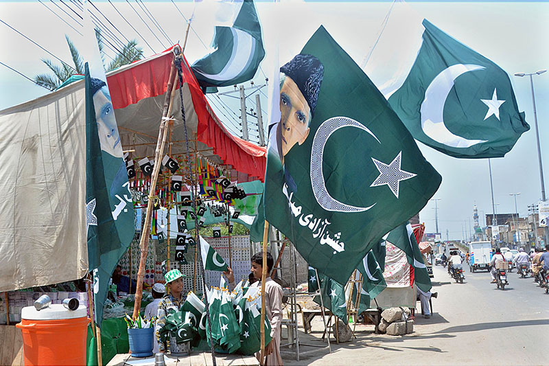 Vendors displaying national flags to attract the customer's in preparation of upcoming Independence Day celebration of Pakistan