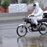 A motorcyclist passing through water during rain that experiences in the city