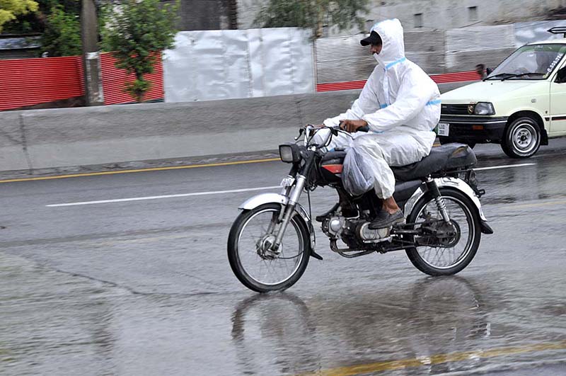 A motorcyclist passing through water during rain that experiences in the city