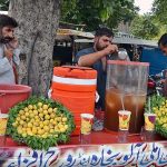 A vendor preparing and selling lemonade at his roadside setup