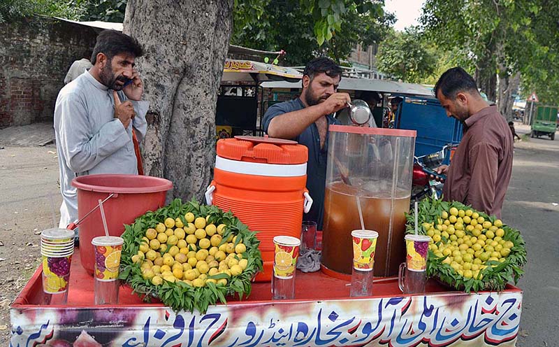 A vendor preparing and selling lemonade at his roadside setup