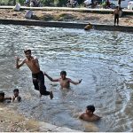 Youngsters jumping into canals to bathe in the rising heat and humid weather in the provincial capital