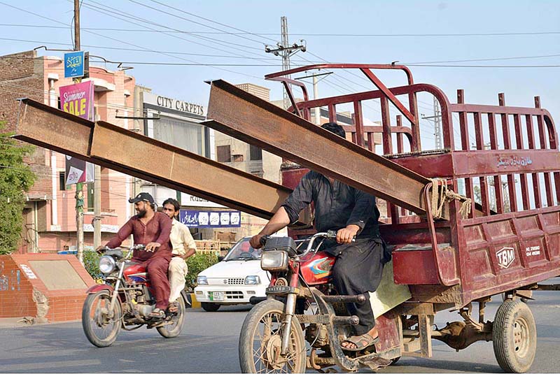 A tricycle rickshaw holder on the way loaded with irin bars at Nori Gate