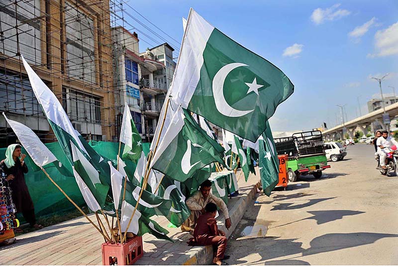 Vendor displaying National flags to attract the customers as the nation starts preparations to celebrate Independence Day in befitting manners at roadside