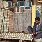 A worker preparing traditional curtains at his workplace