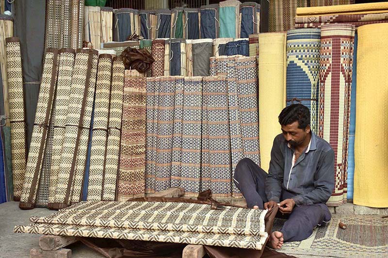 A worker preparing traditional curtains at his workplace