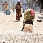 Laborers busy in construction work of District Jail Road during development work in the city.