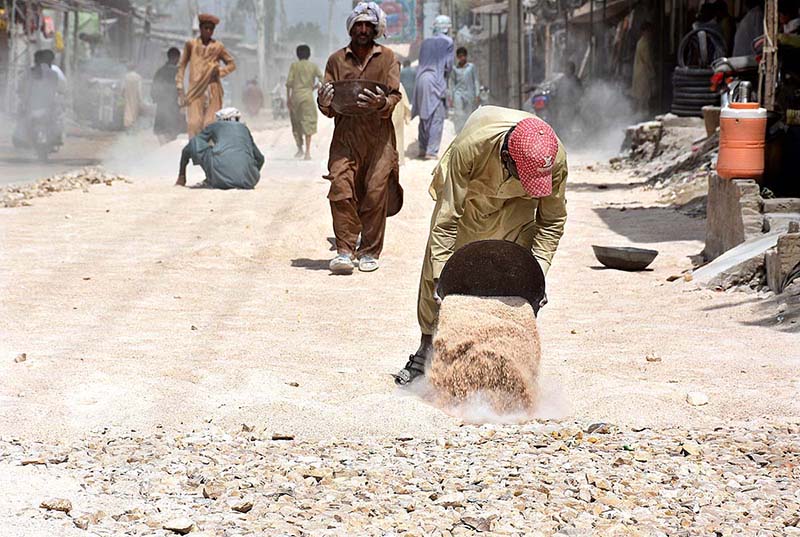 Laborers busy in construction work of District Jail Road during development work in the city.