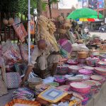 Vendors displaying handmade household items at his roadside setup
