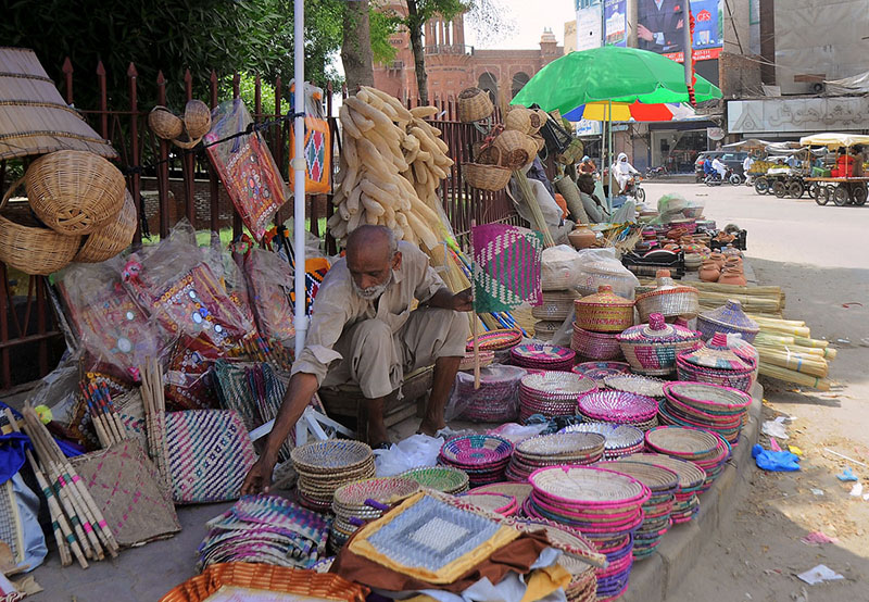 Vendors displaying handmade household items at his roadside setup