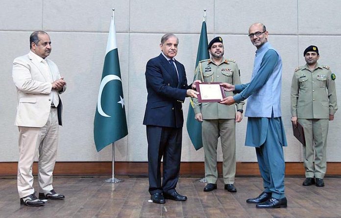 Prime Minister Muhammad Shehbaz Sharif distributing appreciation certificates among the staff of the PM House and PM Office