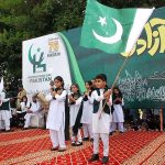 Children are reciting the National anthem and waving the National flag during a ceremony organized on the occasion of 77th Independence Day celebration