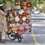A street vendor displaying hand-made domestic use items to attract customers at roadside