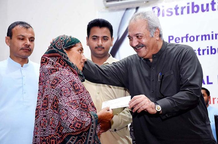 Political Secretary to PPP Chairman, Jameel Ahmed Soomro distributing gratuity checques to retired employees of Larkana Municipal Corporation during a ceremony at Begum Nusrat Bhutto Hall Jinnah Bagh.