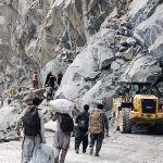 People crossing the blocked road on Juglot Skardu Road after land sliding near Rondu area