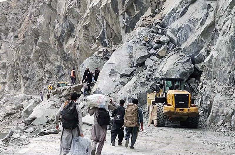 People crossing the blocked road on Juglot Skardu Road after land sliding near Rondu area